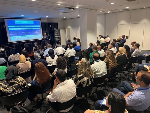 Un grand groupe de personnes assises dans une salle. Événement sur la Conformité des Délais de Paiement.